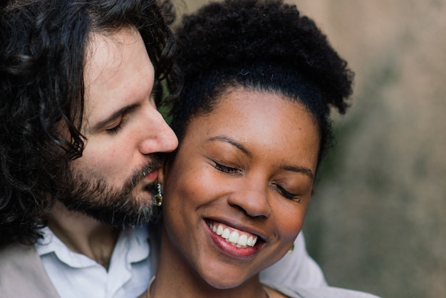 Junges erwachsenes interracial Paar auf einem Strand, kaukasischer Mann und Afroamerikanerfrau in der Freizeitkleidung, die Sommertag am Meerufer genießt