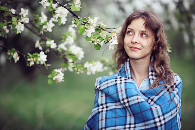 Junges erwachsenes Mädchen genießt den Duft von Frühlingsblumenapfel