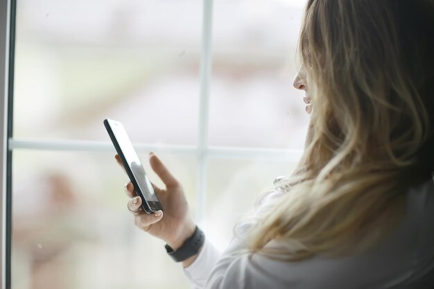 Junges erwachsenes Mädchen mit Telefon