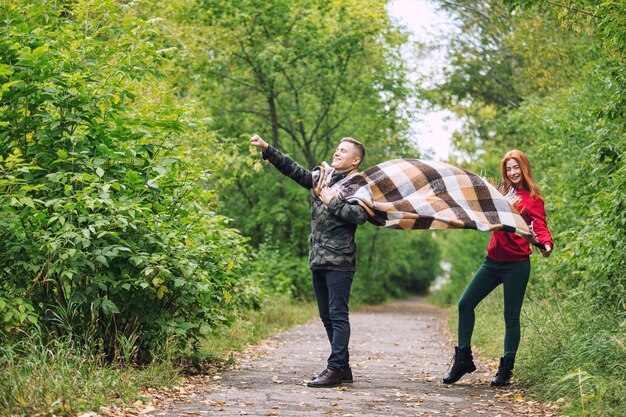 Junges erwachsenes schönes Paar in der Liebe, die zusammen in der Natur im Park geht