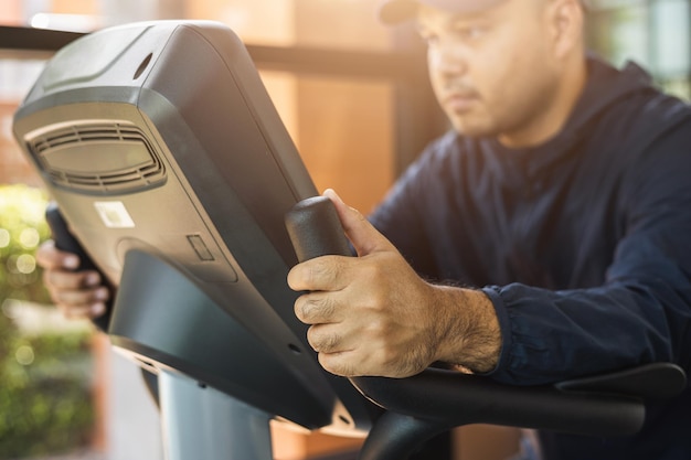 Junges Fitness-Mann-Training mit Fahrradmaschine Indoor-Fitnessstudio. Männliche Übung Cardio auf Fahrradmaschine. Sport- und Gesundheitstraining im Sportverein