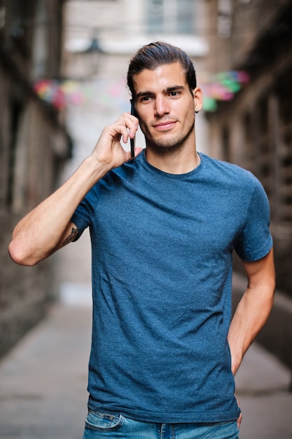 Junges Fitnessmodel mit Smarphone mit blauem T-Shirt