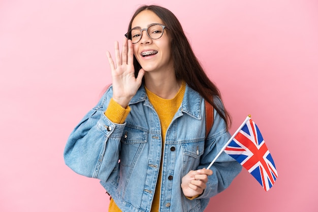 Junges französisches Mädchen, das eine Flagge des Vereinigten Königreichs isoliert hält