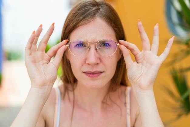 Junges französisches Mädchen im Freien mit Brille und frustriertem Ausdruck