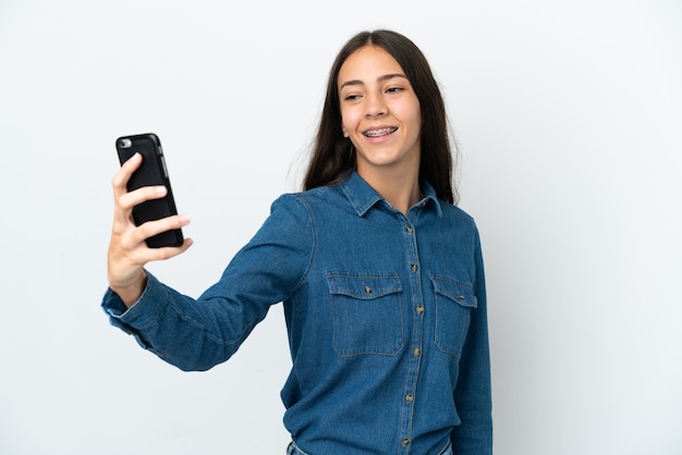 Junges französisches Mädchen isoliert auf weißem Hintergrund, das ein Selfie mit dem Handy macht