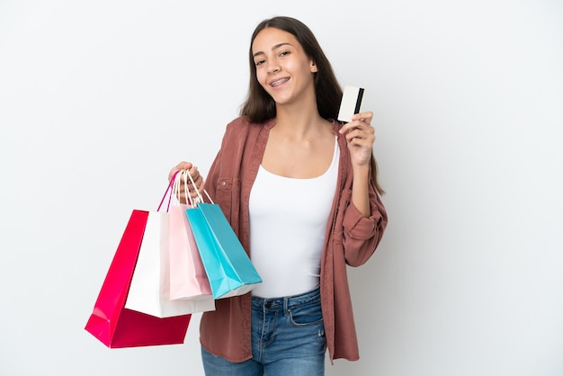 Junges französisches Mädchen lokalisiert auf weißem Hintergrund, der Einkaufstaschen und eine Kreditkarte hält