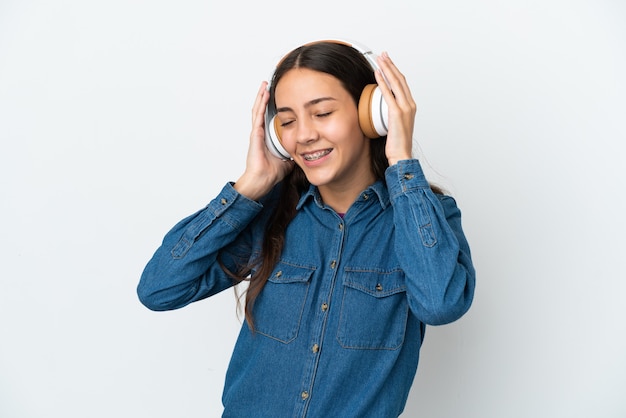 Junges französisches Mädchen lokalisiert auf weißem Hintergrund, der Musik hört