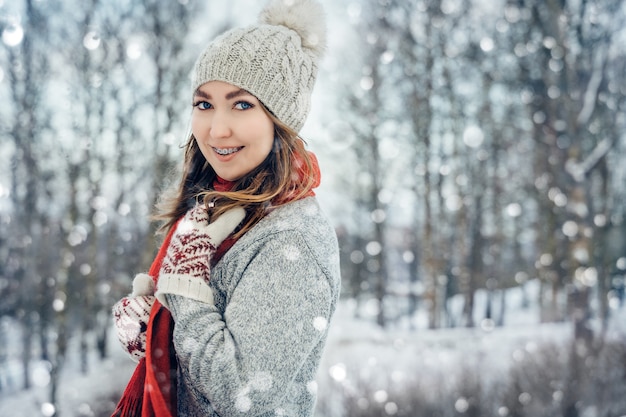 Junges Frauenporträt des Winters fröhliches Modellmädchen, das im Winterpark lacht und Spaß hat