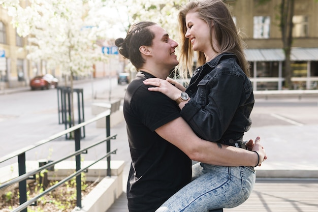 Junges fröhliches und lächelndes Paar bei einem Date im Freien