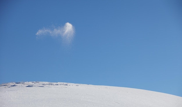 Junges glückliches Mädchen spielt mit Schnee