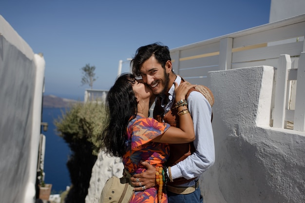 Junges glückliches Paar Mann und Frau an einer griechischen Kirche in Oia Thira Cyalides Santorini Griechenland