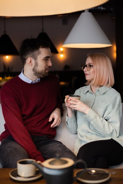 Junges glückliches romantisches liebespaar, das tee im café trinkt.