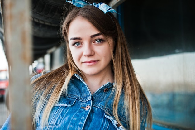 Junges Hipster-Mädchen in Jeansjacke und Kopftuch in der Reifenmontagezone