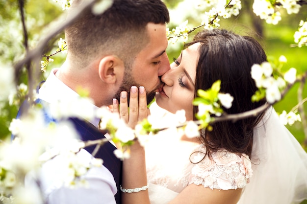 Junges Hochzeitspaar, das romantische Momente draußen auf einer Sommerwiese genießt