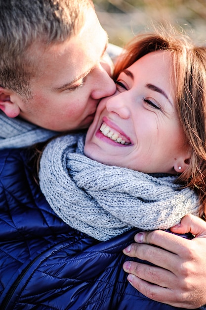 Junges hübsches Mode sinnliches Paar in der Liebe, die im kalten Winterfeld sitzt