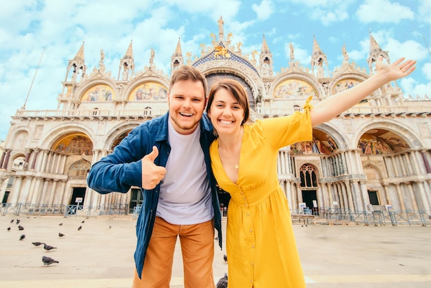 Junges hübsches Paar, das vor der Markusbasilika Venedig Italien posiert