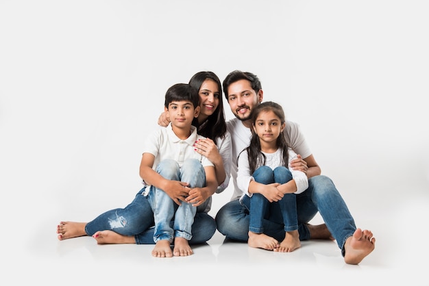 Junges indisches asiatisches Familiensitzen lokalisiert über weißem Hintergrund. selektiver Fokus