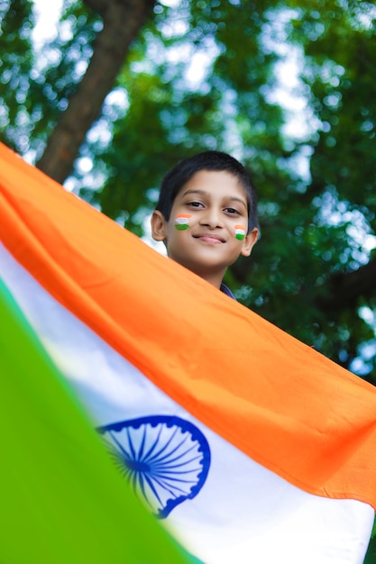 Junges indisches Kind mit indischer Flagge auf Gesicht