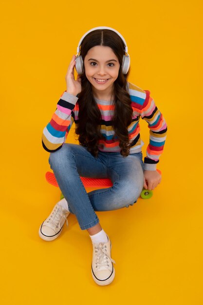 Junges jugendlich Kind, das Musik mit Kopfhörern hört Mädchen, das Lieder über drahtlose Kopfhörer hört Drahtloses Headset-Gerätezubehör Glücklicher Teenager, positive und lächelnde Emotionen von Teenager-Mädchen