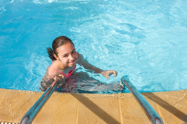 Junges jugendlich Mädchen schwimmt und hat Spaß im Außenpool