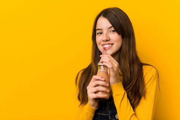 Junges kaukasisches Mädchen, das einen Smoothie hält