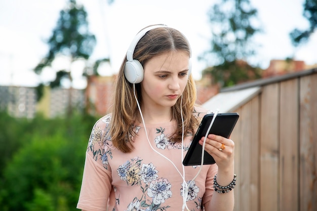 Junges kaukasisches Mädchen, das in ihr Handy schaut