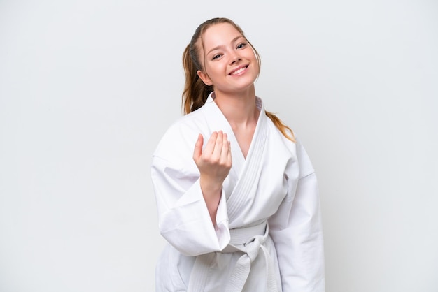 Junges kaukasisches Mädchen, das Karate lokalisiert auf weißem Hintergrund tut, das einlädt, mit Hand zu kommen Glücklich, dass Sie gekommen sind