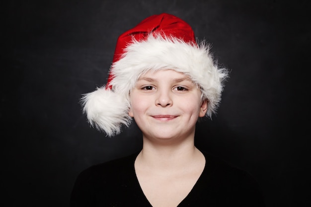 Junges Kind in Weihnachtsmütze auf Tafel Hintergrund