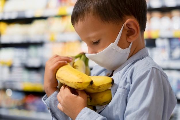 Foto junges kind mit masken einkaufen