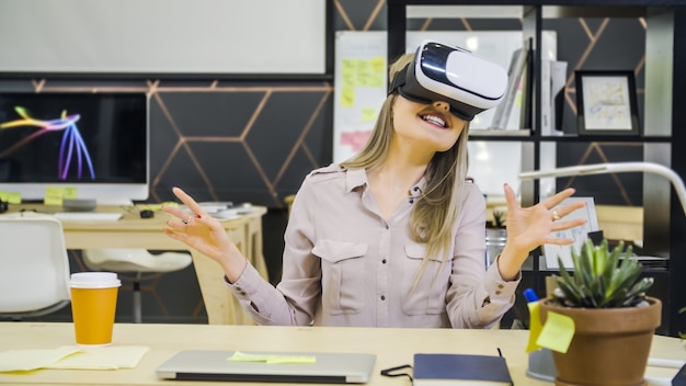 Junges kreatives Mädchen verwendet VR-Brille am Arbeitsplatz