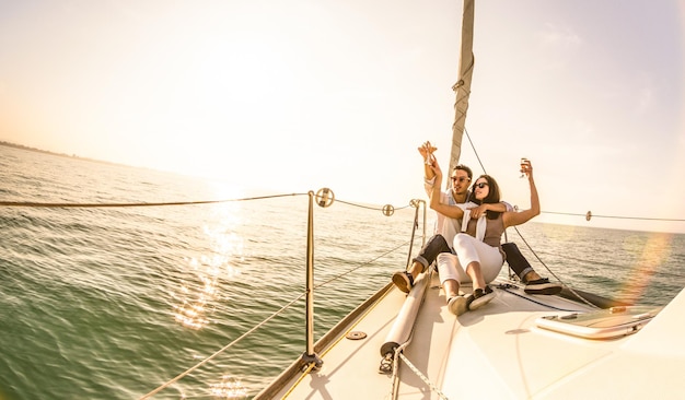 Junges Liebespaar auf Segelboot mit Champagner bei Sonnenuntergang