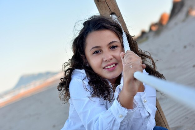 Junges Mädchen auf der Strandnahaufnahme, die mit Seil spielt