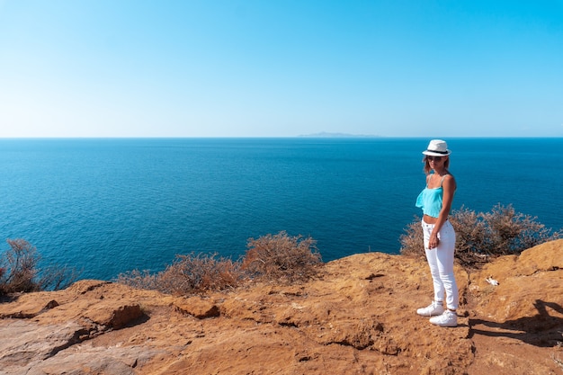 Junges Mädchen auf einer hohen Klippe über dem Meer