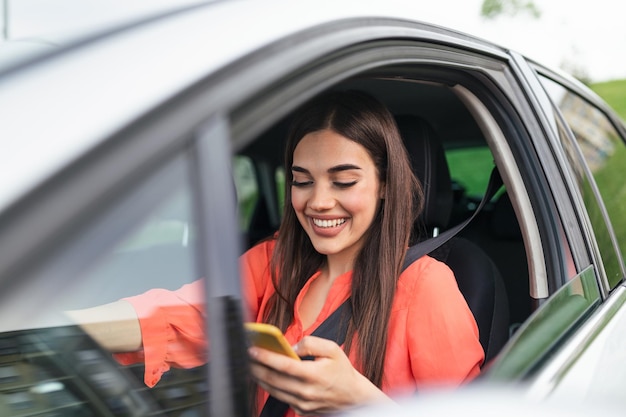 Junges Mädchen benutzt ein Mobiltelefon im Auto Technologie Mobiltelefon-Isolation Internet und soziale Medien Frau mit Smartphone in ihrem Auto Mädchen benutzt ein Smartphone