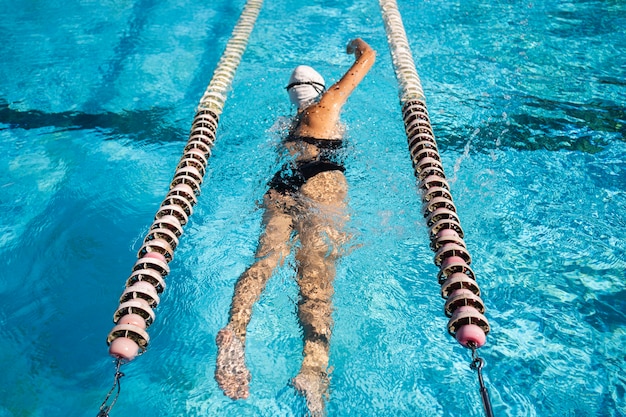 Foto junges mädchen, das das schwimmen am pool genießt