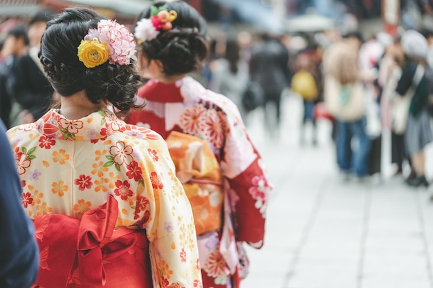 Junges Mädchen, das den japanischen Kimono steht vor Sensoji-Tempel in Tokyo trägt