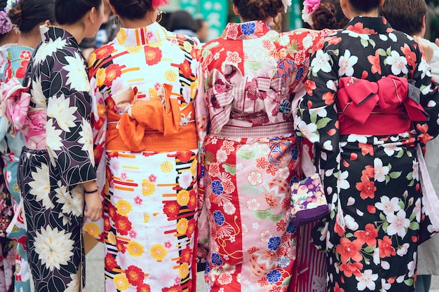 Junges Mädchen, das den japanischen Kimono steht vor Sensoji-Tempel trägt