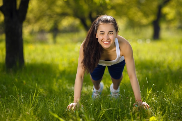 Junges Mädchen, das draußen ausarbeitet. Schönheit, die pilates, Yoga und Eignungsübungen auf Natur tut.