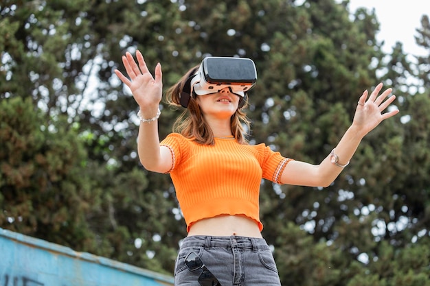 Junges Mädchen, das ein VR-Set trägt und ihre Hände in die Luft hält