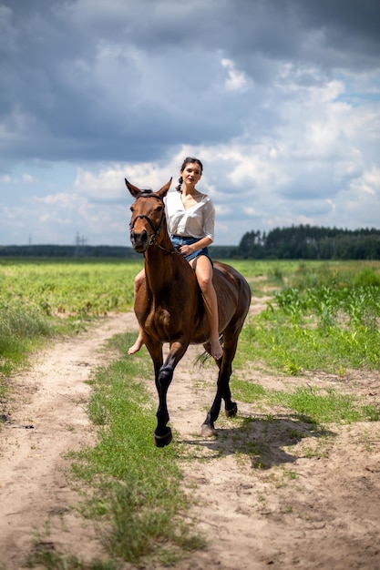 Junges mädchen, das eine braune pferdenahaufnahme reitet