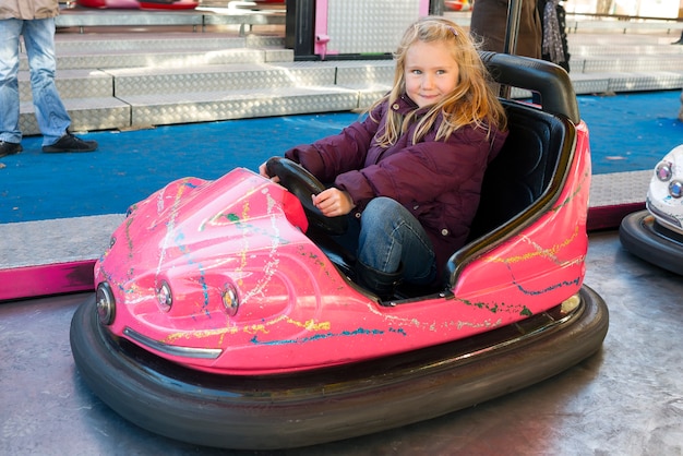 Foto junges mädchen, das einen autoscooter fährt