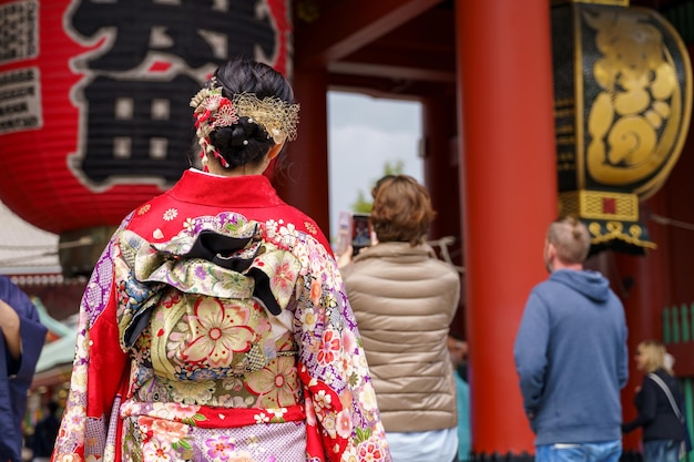 Junges Mädchen, das einen japanischen Kimono trägt und vor dem Sensoji-Tempel in Tokio steht. Japan Kimono ist ein traditionelles japanisches Kleidungsstück. Das Wort Kimono bedeutet eigentlich etwas zu tragen