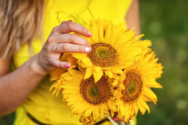 Foto junges mädchen, das einen strauß sonnenblumen hält