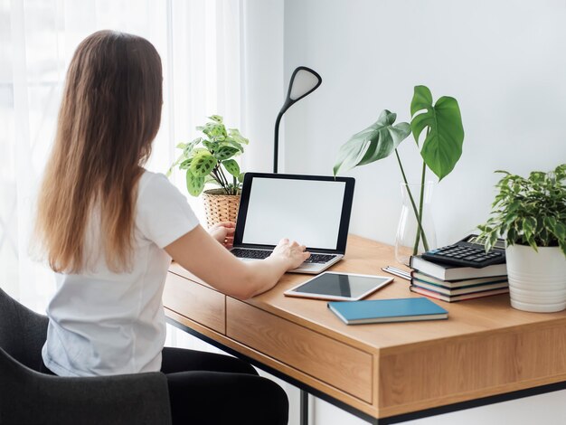 Junges Mädchen, das im Homeoffice am Tisch arbeitet