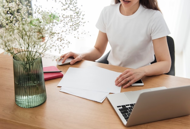 Junges Mädchen, das im Homeoffice am Tisch arbeitet