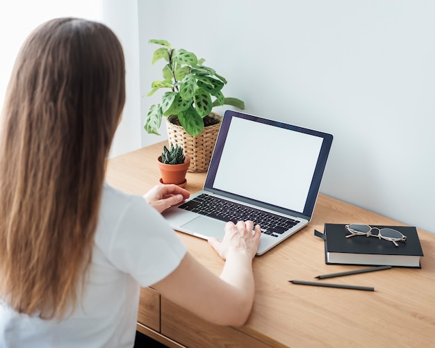 Junges Mädchen, das im Homeoffice am Tisch arbeitet