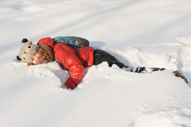 Junges Mädchen, das im Schnee spielt