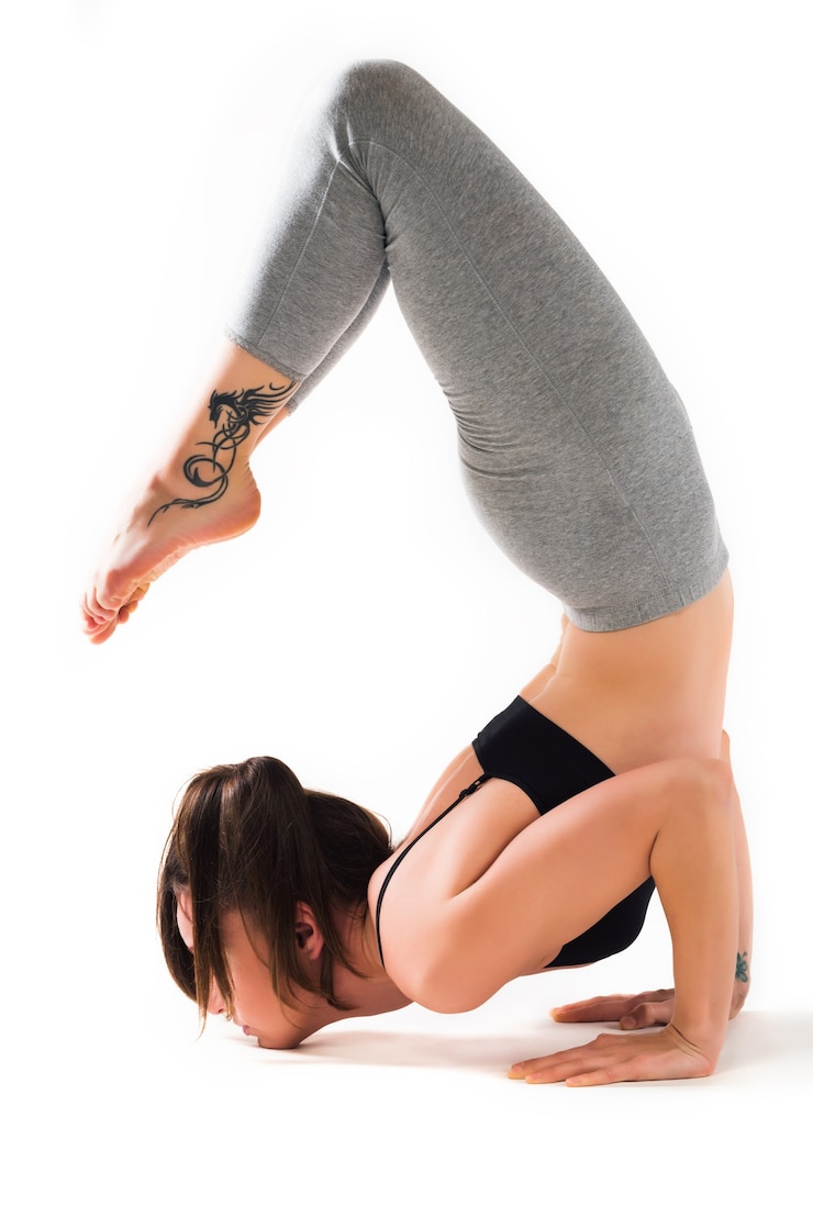 Foto junges mädchen, das in einer yoga-pose auf einem weißen hintergrund sitzt