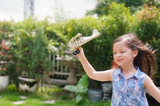 Junges Mädchen, das mit Spielzeugflugzeug spielt