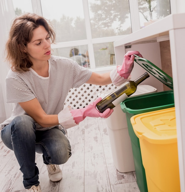 Junges Mädchen, das Müll an der Küche sortiert. Konzept des Recyclings. Kein Verlust